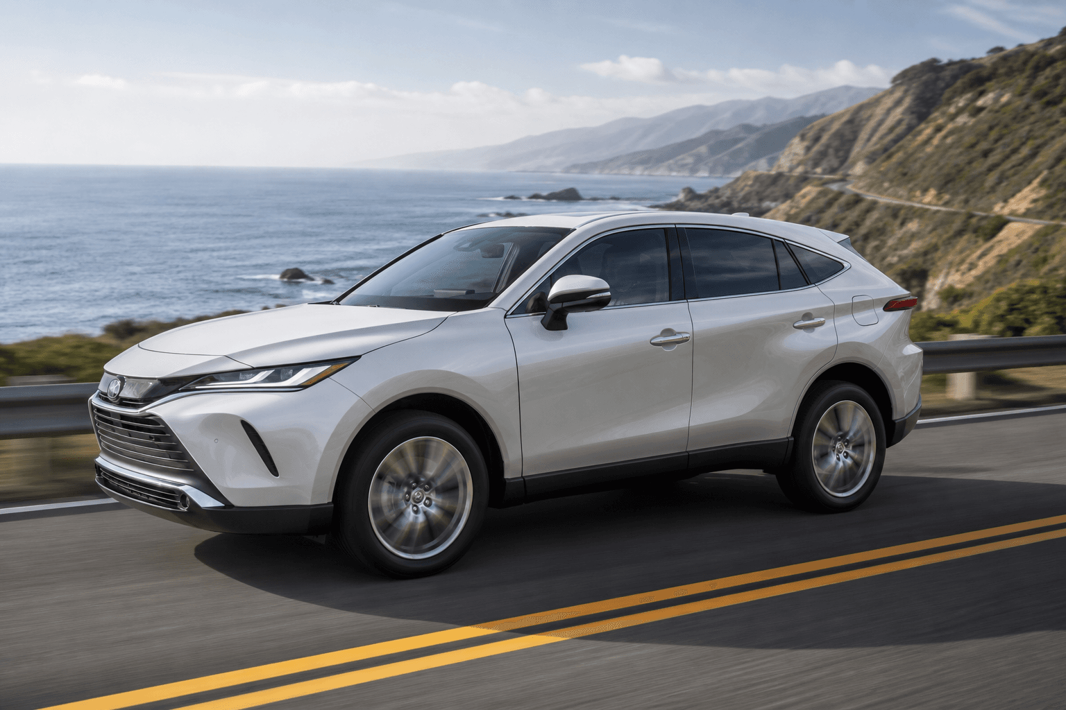 Pearl white Toyota Harrier SUV on a coastal highway