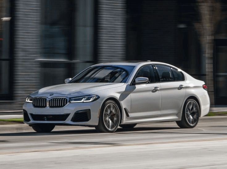 Silver BMW 5 Series sedan in motion, front three-quarter view